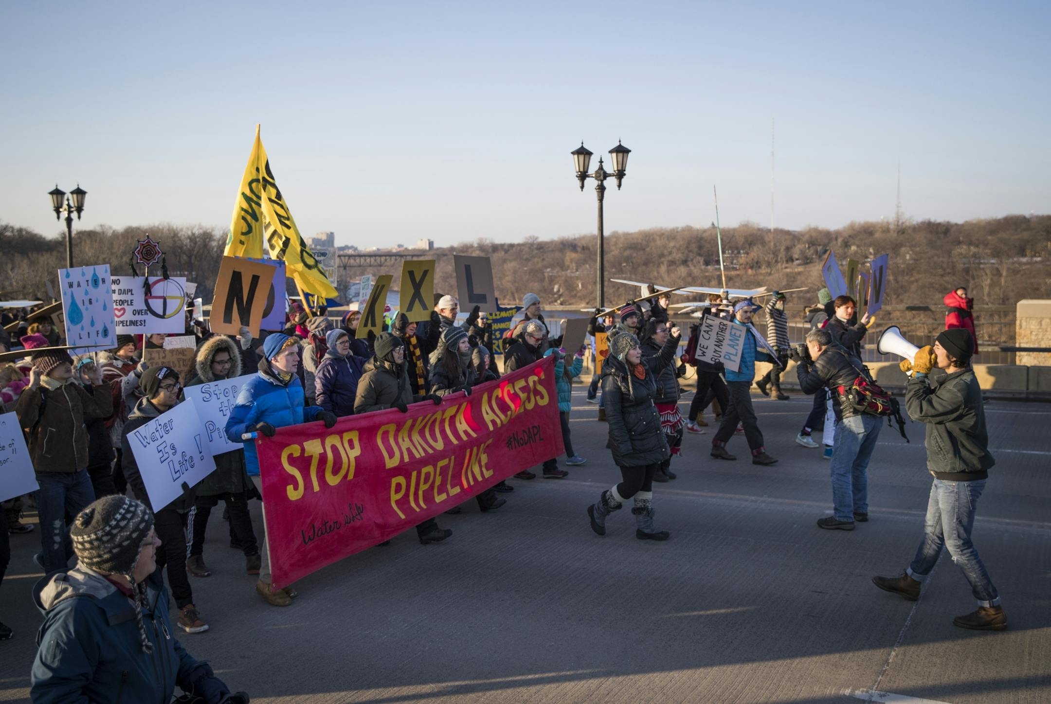 A group of close to 300 people marched from Minneapolis, across the Marshall Avenue (Lake Street) bridge and met with another group of about 200 people marching from St. Paul to protest the Dakota Access Pipeline on Friday, January 27, 2016.