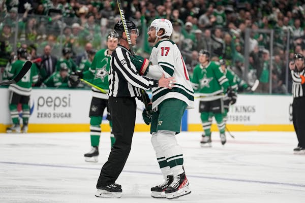 Linesman David Brisebois escorts the Wild's Marcus Foligno off the ice after Foligno was issued a game misconduct in the first period of Game 5.
