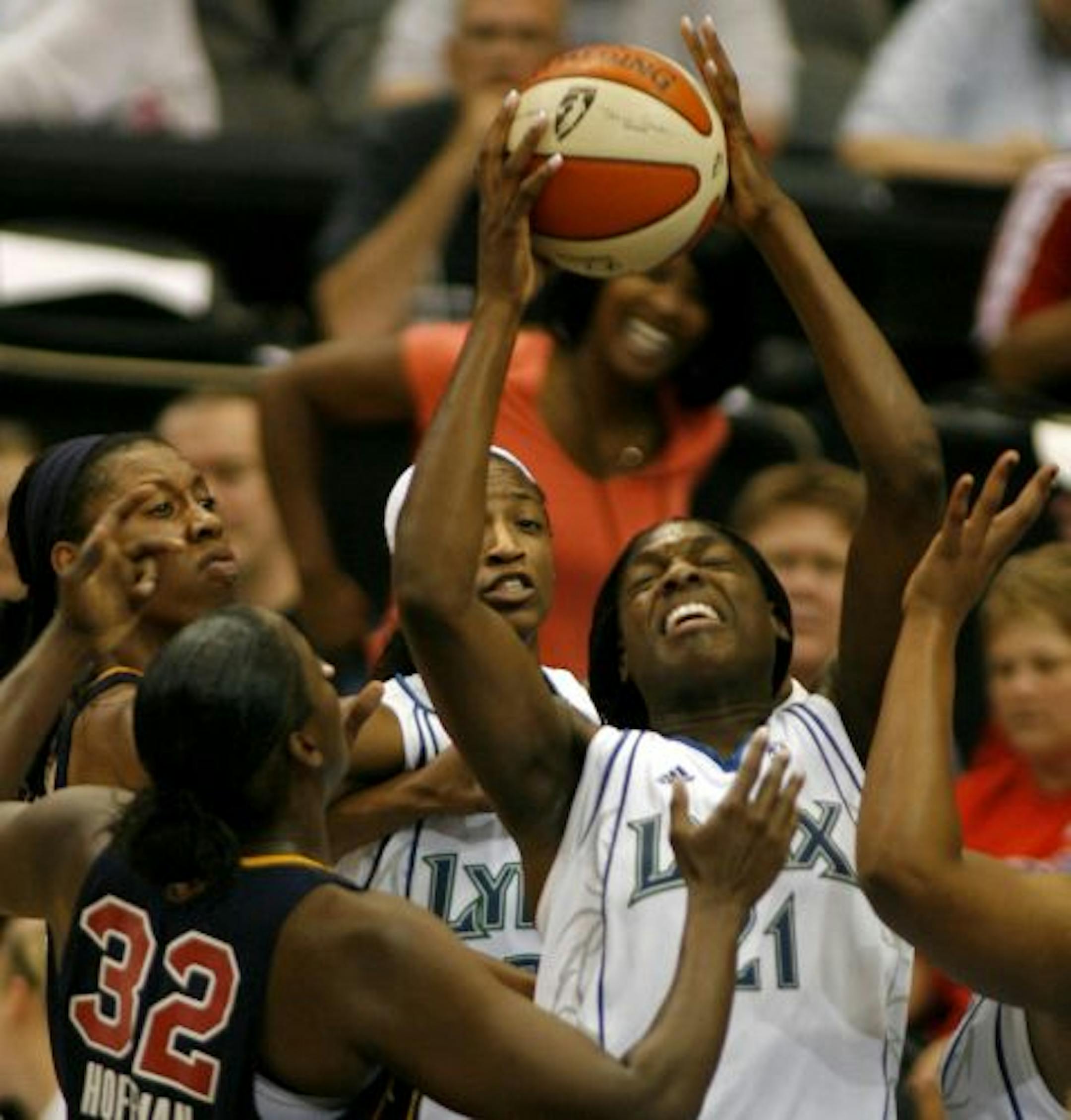 The Minnesota Lynx's Nicky Anosike (24) pulls down a rebound over the Indiana Fever's Ebony Hoffman (32) as the Lynx's Rashanda McCants, center, looks on during 1st quarter action of the WNBA game at the Target Center in Minneapolis.