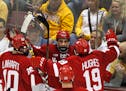 Wisconsin forward Luke Kunin (9) is congratulated by teammates Jake Linahrt and Cameron Hughes after scoring a goal against the Gophers on March 11 at