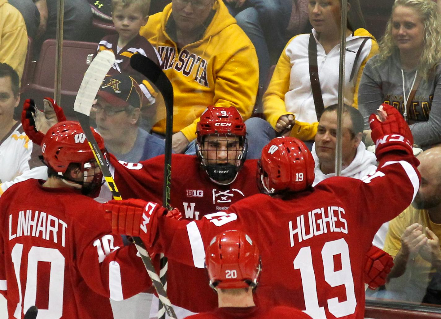 Wisconsin forward Luke Kunin (9) is congratulated by teammates Jake Linahrt and Cameron Hughes after scoring a goal against the Gophers on March 11 at Mariucci Arena.