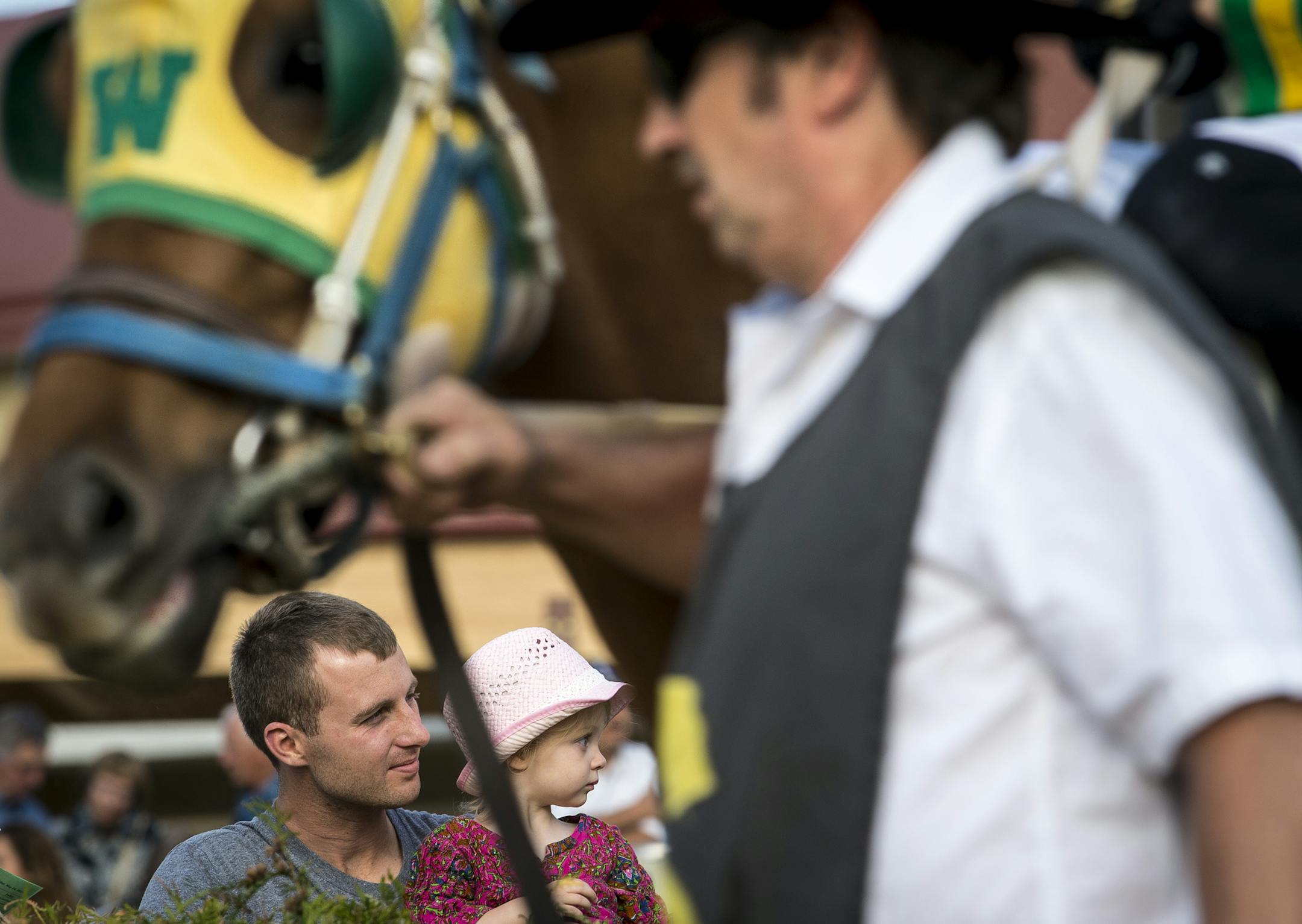 Mitch Grengs and his daughter, Bel, 2, of St. Paul, watched as horses were brought from the paddock to the track after being mounted by their jockeys before the first race Friday night. ] (AARON LAVINSKY/STAR TRIBUNE) aaron.lavinsky@startribune.com The racing season kicked of at Canterbury Park on Friday, May 20, 2016 in Shakopee, Minn.