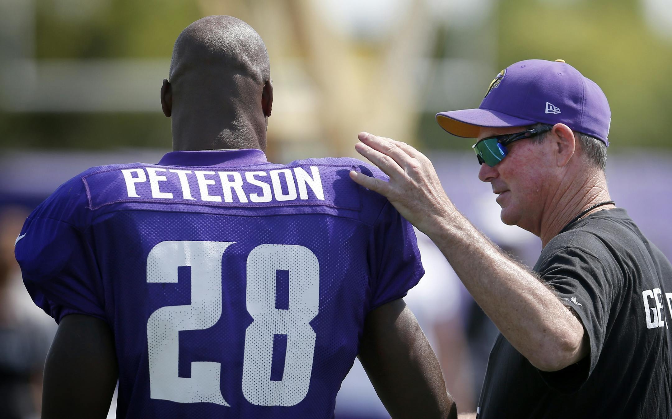 Minnesota Vikings head coach Mike Zimmer spoke with running back Adrian Peterson (28) at training camp