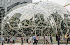 Pedestrians walk past a recently built trio of geodesic domes that are part of the Seattle headquarters for Amazon, Sept. 7, 2017. The online retail g
