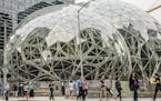 Pedestrians walk past a recently built trio of geodesic domes that are part of the Seattle headquarters for Amazon, Sept. 7, 2017. The online retail g