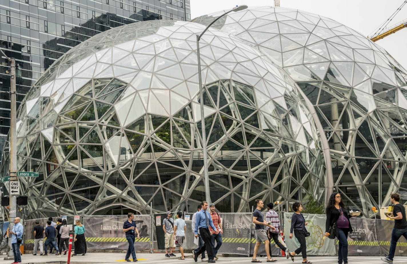 Pedestrians walk past a recently built trio of geodesic domes that are part of the Seattle headquarters for Amazon, Sept. 7, 2017. The online retail giant said it was searching for a second headquarters in North America in 2017, a huge new development that would cost as much as $5 billion to build and run, and house as many as 50,000 employees. (Stuart Isett/The New York Times)