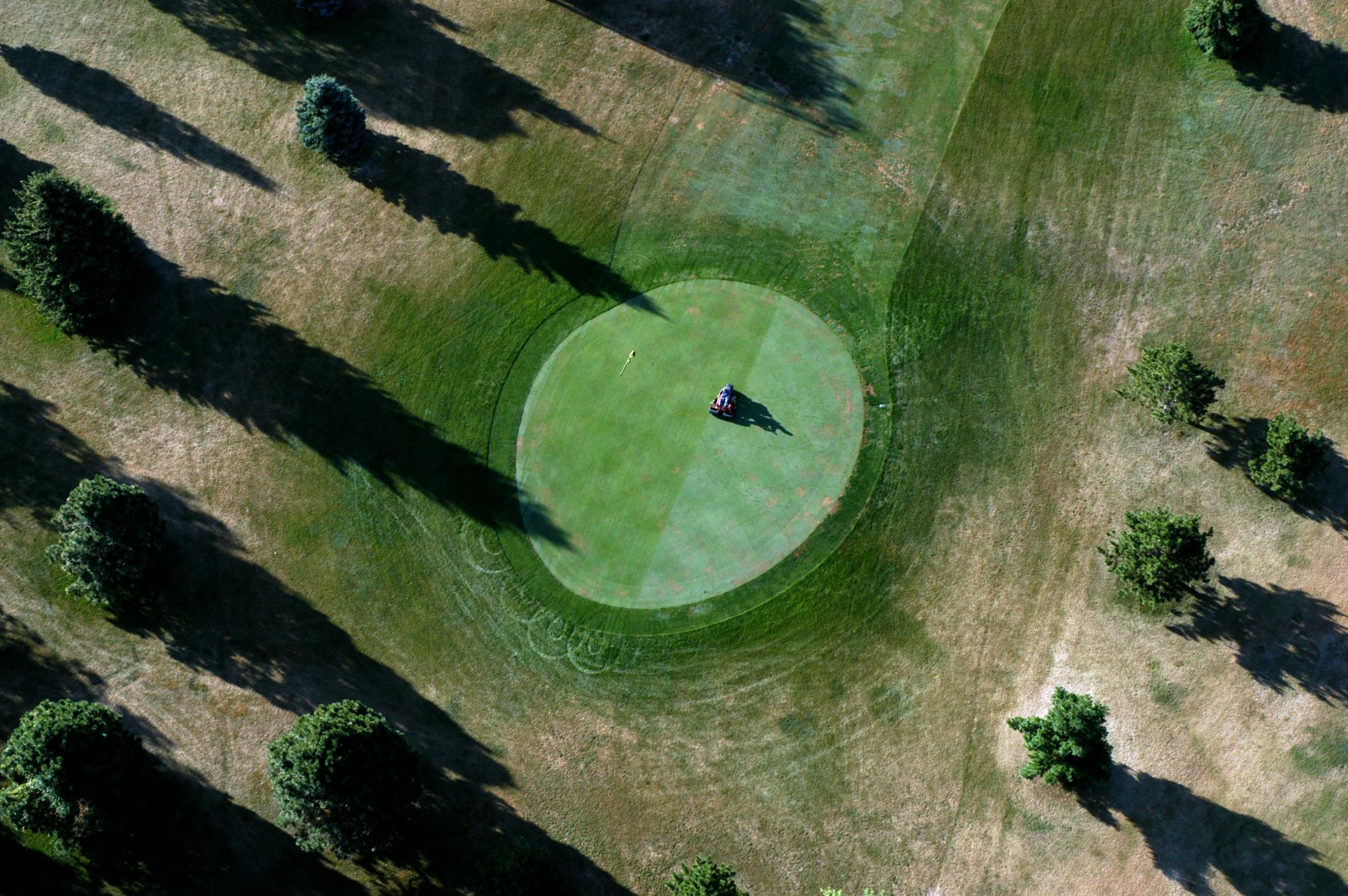 A grounds keeper trims one of the greens at Hollydale golf course in Plymouth.