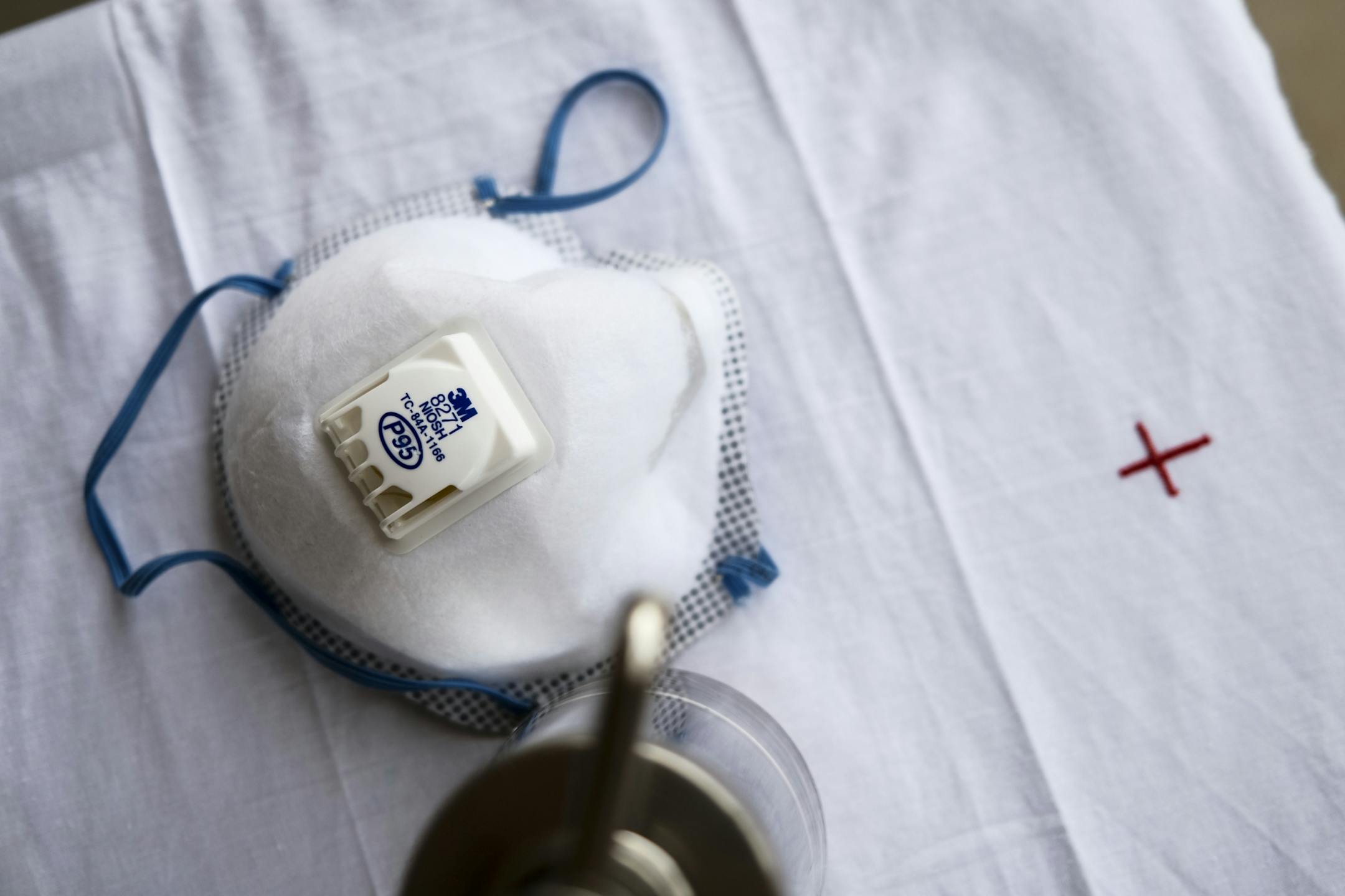 A 3M respirator mask on a table outside Transfiguration Church as Fr. Brian Lynch led evening mass Wednesday.