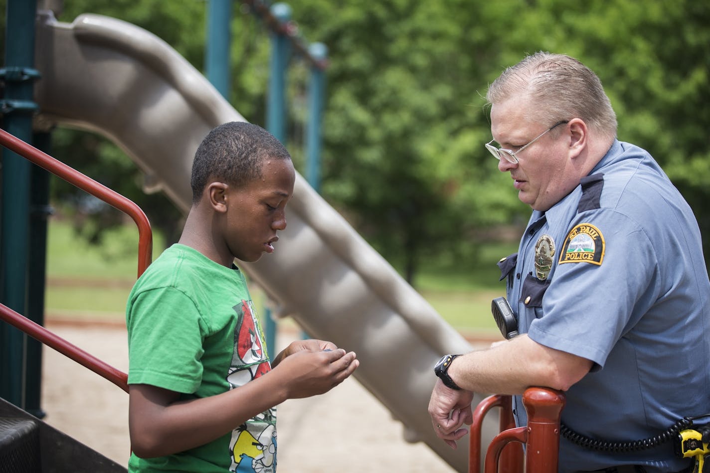 St. Paul Police officer Rob Zink visits with Devont'e Ray-Burns, 12, who has autism and other disabilities, outside Ray-Burns' home in St. Paul on Thursday, July 9, 2015.