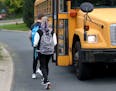 Students board a school bus nicknamed "the secret bus," which takes them from their home in Eden Prairie to school in Minnetonka.