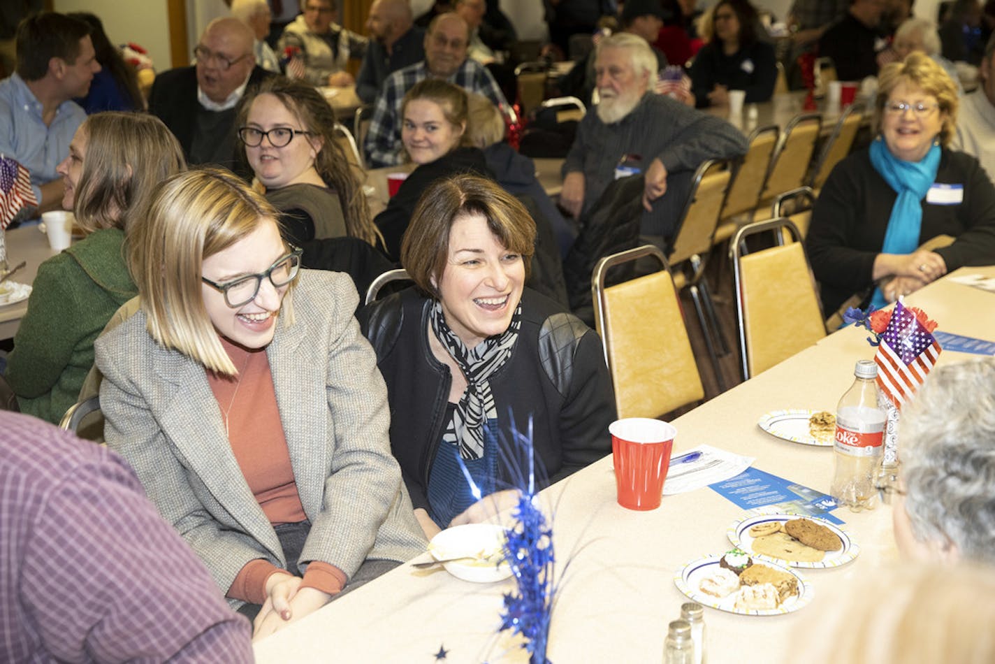 Sen. Amy Klobuchar shared a laugh with her daughter, Abigail Klobuchar Bessler, and supporters while campaigning in Albia, Iowa, on Feb. 17. Klobuchar was in fifth place in an Iowa poll released over the weekend.