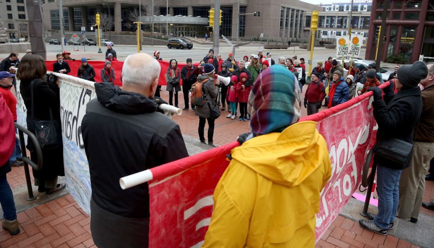 The crowd of more than 50 protesters received instructions before heading out to march for climate change at the Hennepin County Government Center.
