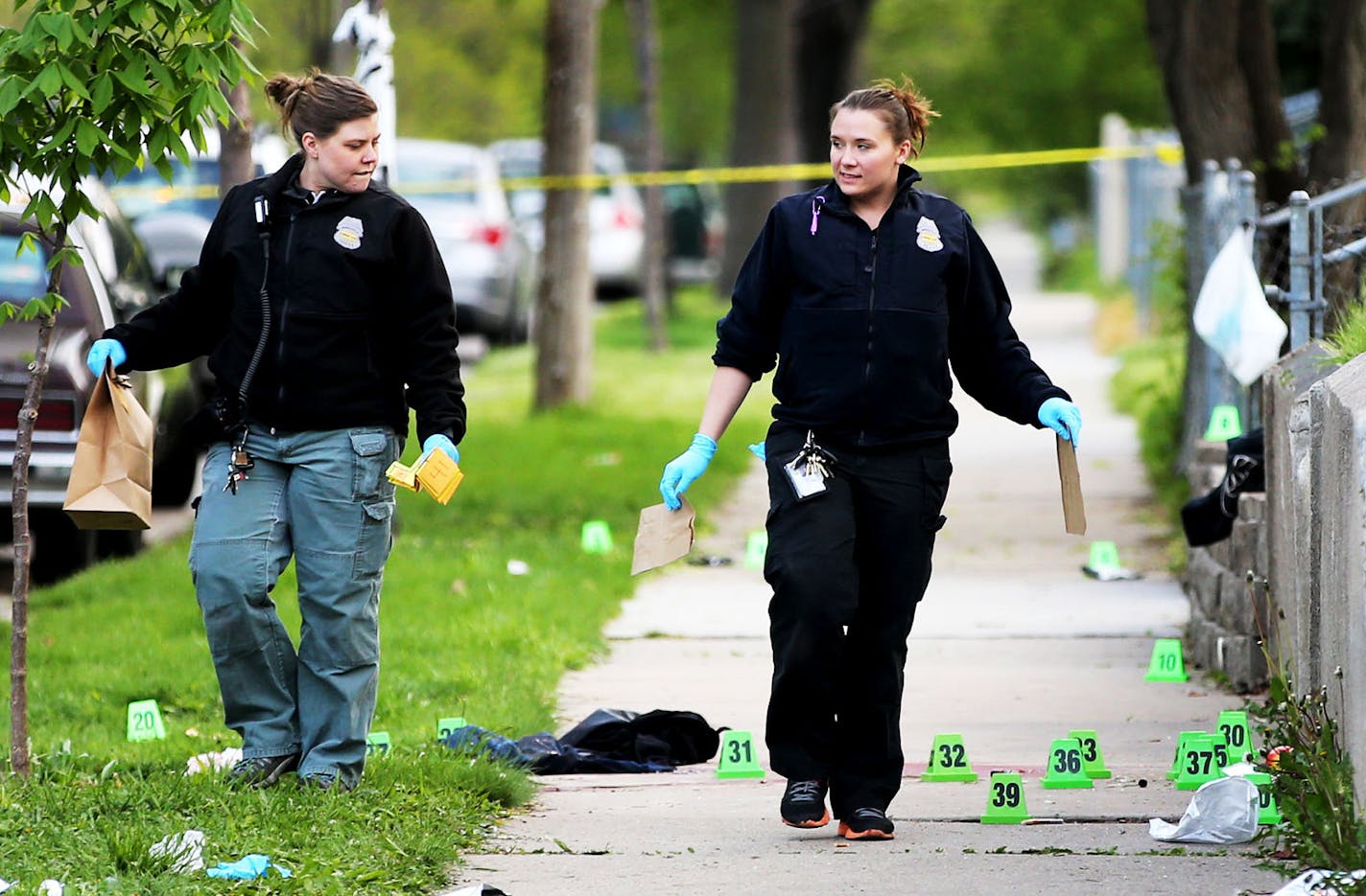 The scene of a multiple shooting where one person was dead and at least two others were in critical condition after six people were shot Wednesday night in north Minneapolis, police said, and seen Thursday, May 5, 2016, in Minneapolis, MN. Here, police investigators pick up evidence.](DAVID JOLES/STARTRIBUNE)djoles@startribune.com One person was dead and at least two others were in critical condition after six people were shot near No 16th Avenue and N Newton Ave. Wednesday night in north Minnea