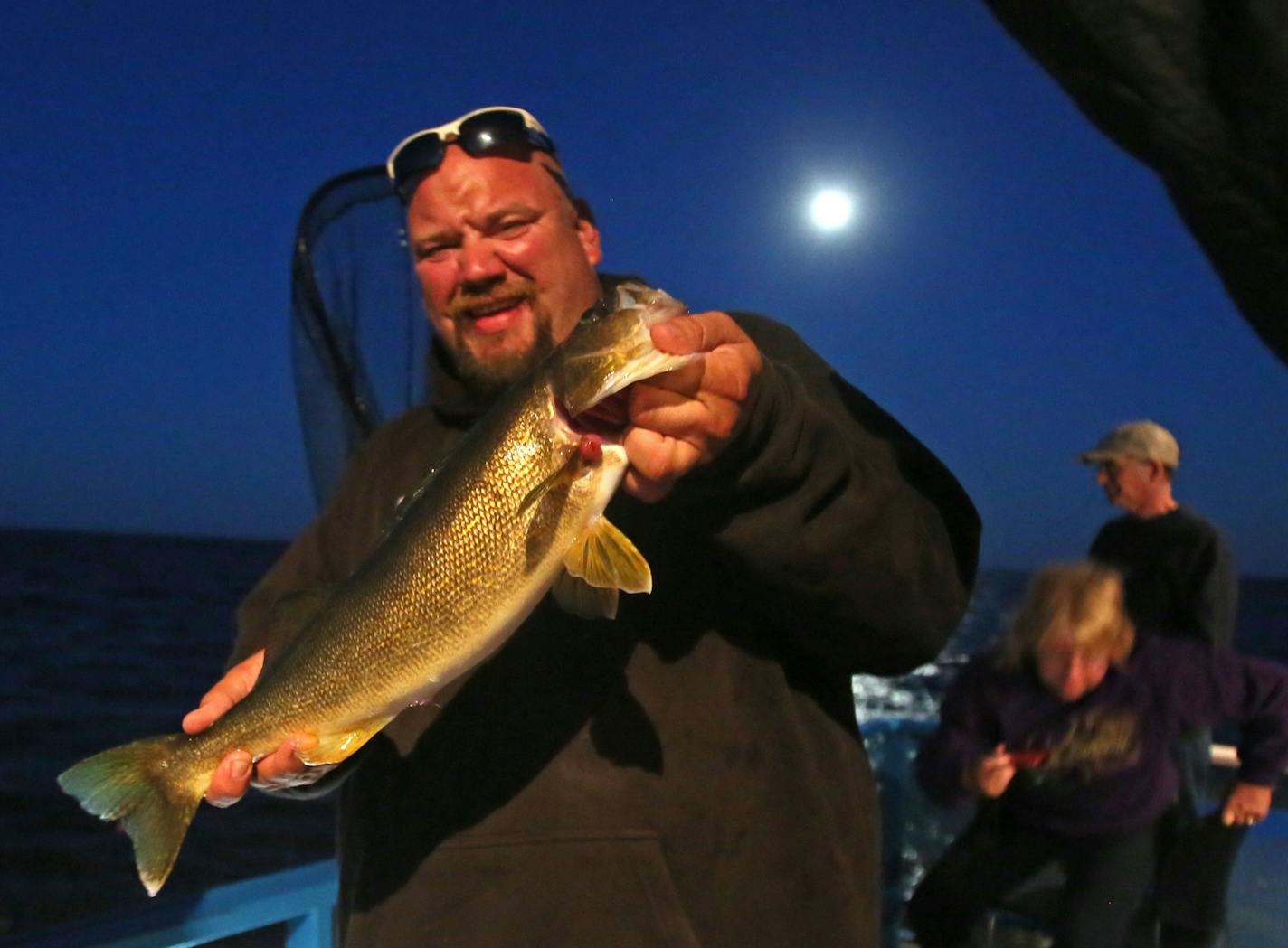 Travis Koster, Twin Pines Resort boat captain and fishing guide holds up a 21 1/2 inch walleye that was released Wednesday, July 29, 2015, caught by client Barb Stirling of Iowa during an evening excursion on Lake Mille Lacs.](DAVID JOLES/STARTRIBUNE)djoles@startribune.com The walleye crisis on Mille Lacs sparked a fresh round of fingerpointing, and fewer targets take more blame than the Mille Lacs Band of Ojibwe and the other bands who net fish in the shallows during spawning season. The racial