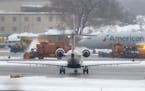 Snow removal equipment operates on a runway at Minneapolis St. Paul International Airport Saturday, Nov. 30, 2019, in Minneapolis, MN.]