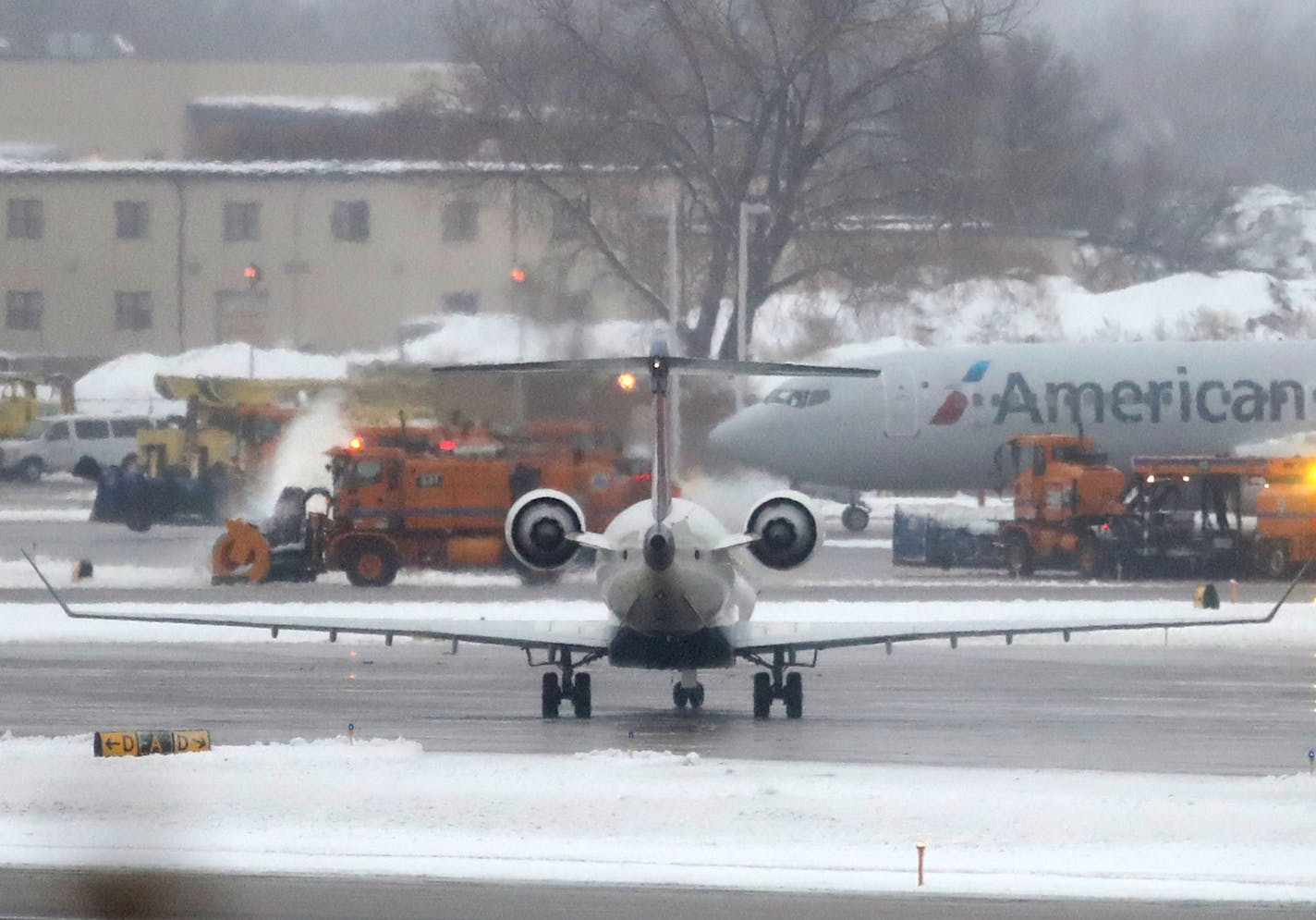 Snow removal equipment operates on a runway at Minneapolis St. Paul International Airport Saturday, Nov. 30, 2019, in Minneapolis, MN.]