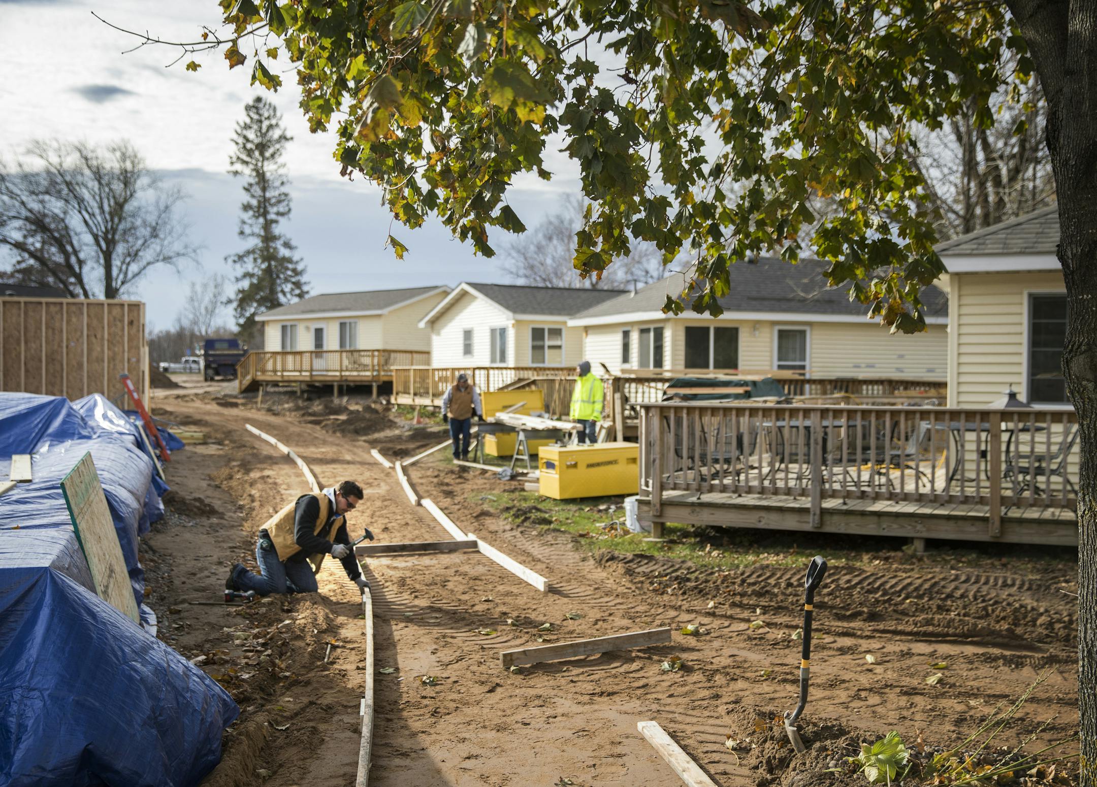 Workers install new sidewalks between cabins on the campground property. ] LEILA NAVIDI ï leila.navidi@startribune.com BACKGROUND INFORMATION: Minnesota Veterans Campground on Big Marine Lake on Friday, November 3, 2017. Attendance at the Minnesota Veterans Campground on Big Marine Lake has grown nearly fivefold since 2010, driven by huge waves of returning veterans from Iraq and Afghanistan. The Washington County camp has undergone numerous major renovations, expansions, and additions, muc