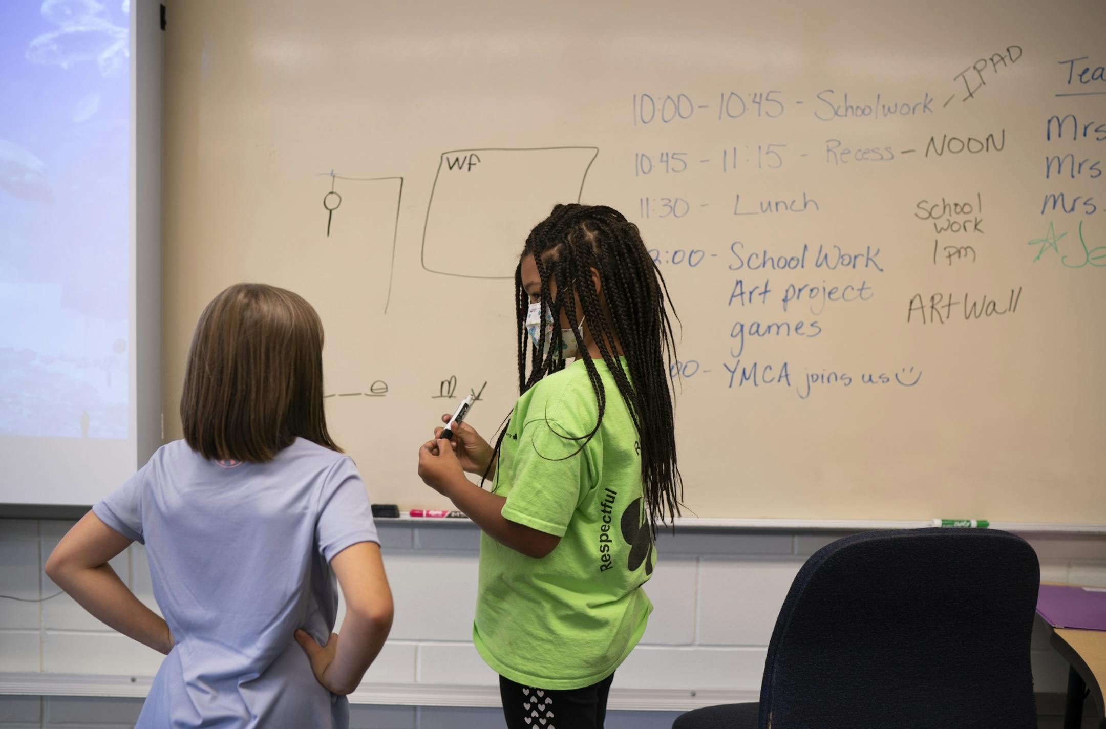 Two second grade kids who'd finished their classwork played a game of hangman before joining other in-school daycare kids for supervision by YMCA staffers.