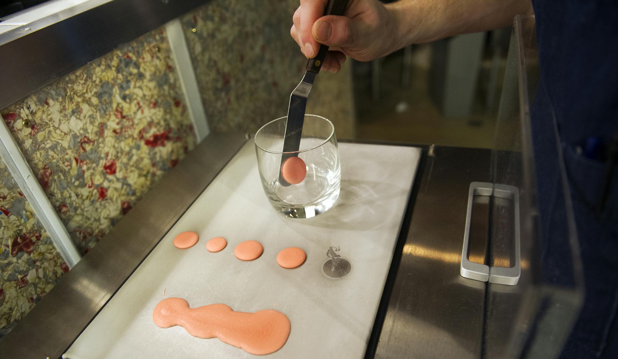 Discs of Campari and bitters, which have been frozen on the sub-zero surface of an anti-griddle, are placed into a glass while making a Negroni at the Rookery in Robbinsdale. (Matthew Hintz, 020714, Robbinsdale)