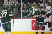 Wild centers Jacob Lucchini (27) and Vinni Lettieri celebrate Lettieri's winning goal during the third period at Xcel Energy Center on Tuesday.