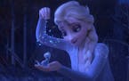 This image released by Disney shows Elsa, voiced by Idina Menzel, sprinkling snowflakes on a salamander named Bruni in a scene from the animated film,