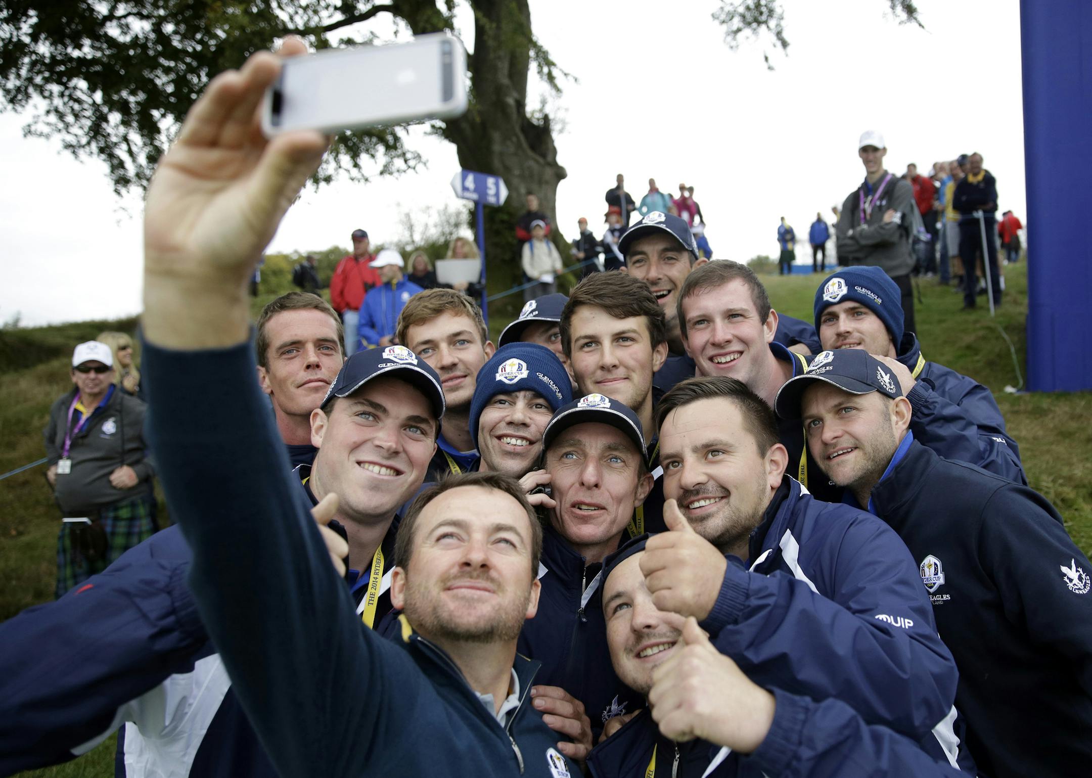 Europe's Graeme McDowell takes a selfie with a group of green keepers after putting out on the 4th green during a practice round ahead of the Ryder Cup golf tournament, at Gleneagles, Scotland, Tuesday, Sept. 23, 2014. (AP Photo/Matt Dunham)