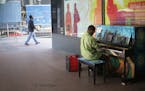 Walter Hampton of St. Paul plays a piano outside of the IDS Center on Wednesday, June 8, 2016. The piano, painted by artist Sam Basques, is one of 25 