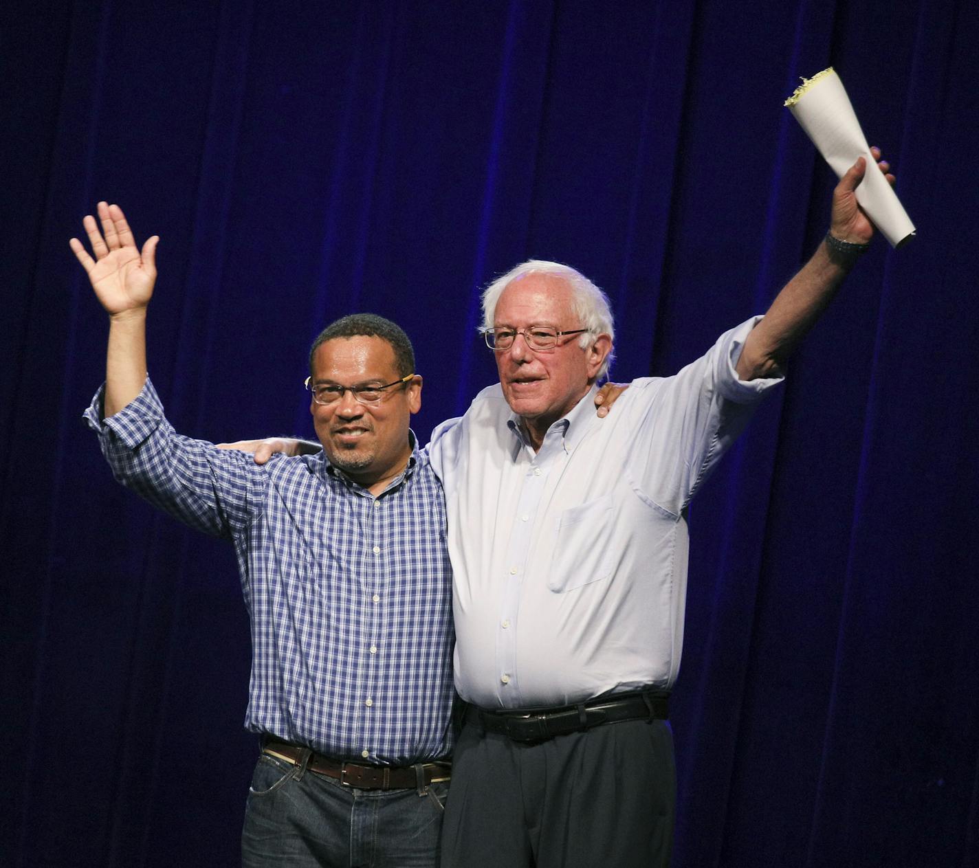 Minnesota Rep. Keith Ellison, left, waves to the audience with Sen. Bernie Sanders, right, at a rally to give support for his attorney general bid at First Avenue Friday, July 13, 2018, in Minneapolis. (Brian Peterson/Star Tribune via AP)