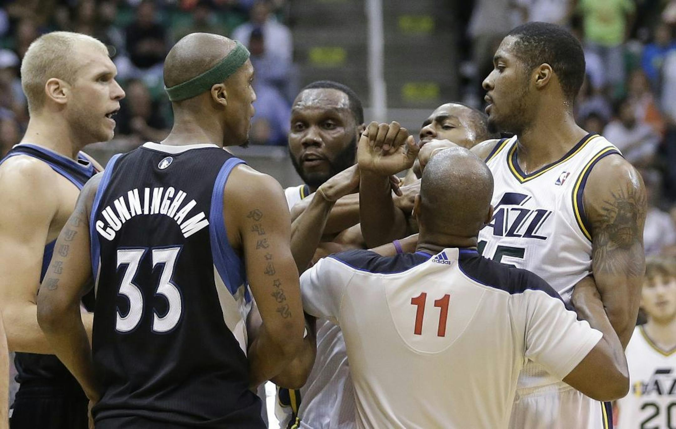 Official Derrick Collins separates Greg Stiemsma, left, and teammate Dante Cunningham from Utah Jazz's Al Jefferson
