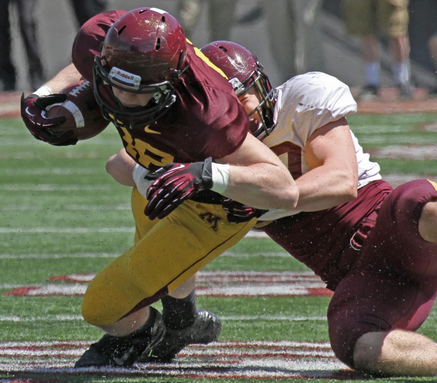 (left to right) Gophers Maroon team Maxx Williams was pulled down by Gophers White Team Nick Rallis during the spring game at TCF Stadium on 4/27/13.] Bruce Bisping/Star Tribune bbisping@startribune.com Maxx Williams, Nick Rallis/roster. ORG XMIT: MIN1304271632311357