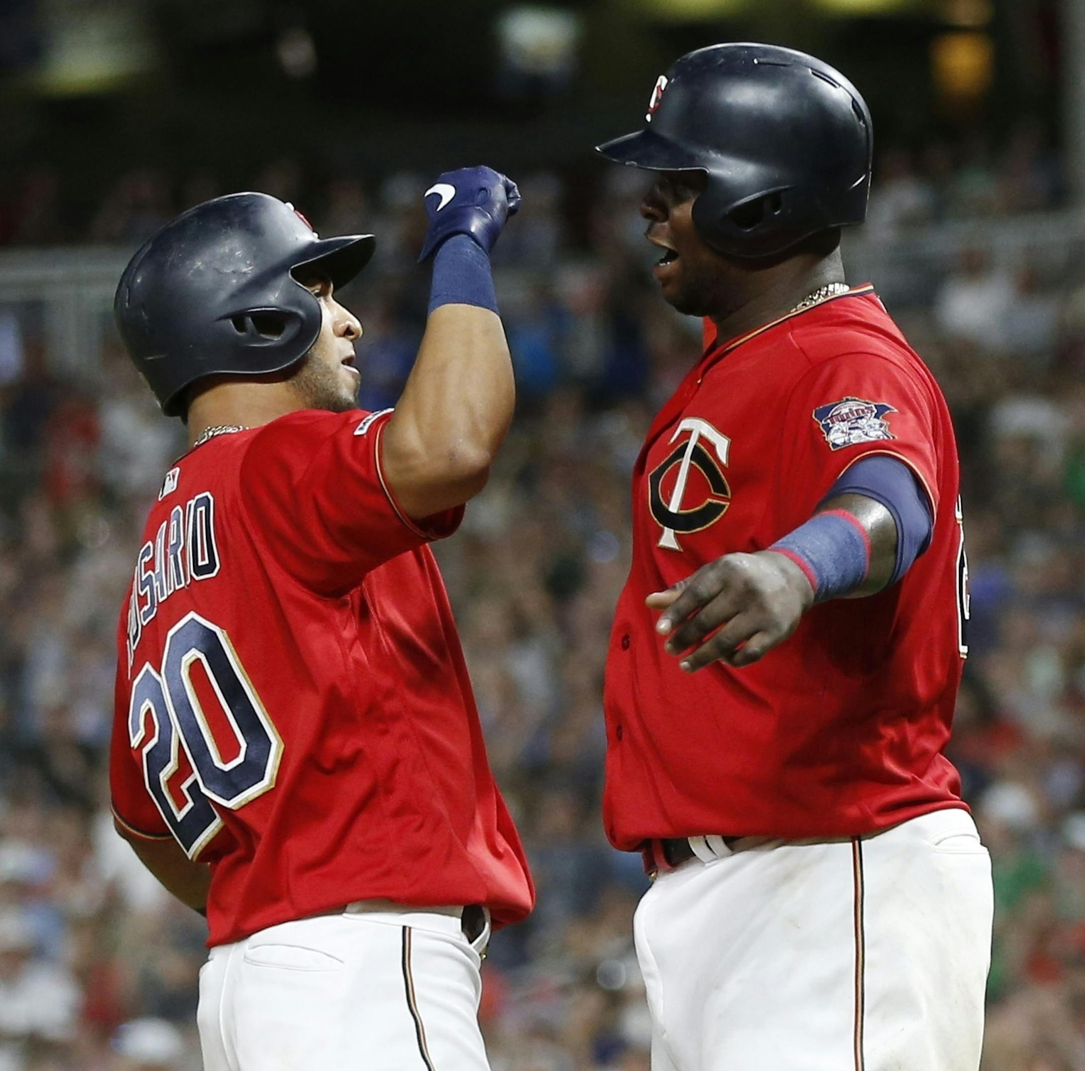 Minnesota Twins' Eddie Rosario, left, and Miguel Sano celebrate Rosario's three-run home run off Oakland Athletics pitcher Yusmeiro Petit during the seventh inning of a baseball game Thursday, July 18, 2019, in Minneapolis. The Twins won 6-3. (AP Photo/Jim Mone)