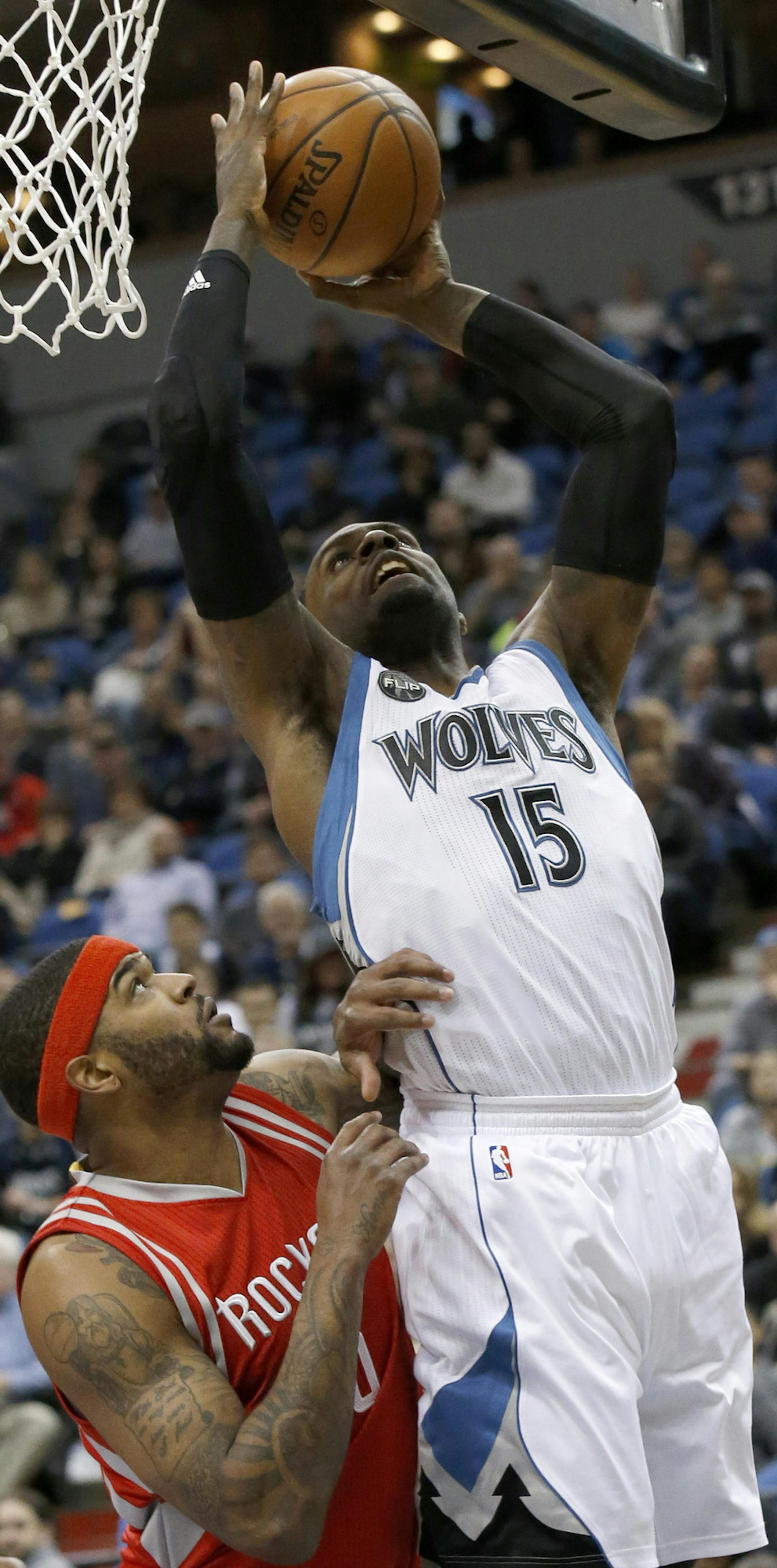 Minnesota Timberwolves forward Shabazz Muhammad, right, goes up fro a shot over Houston Rockets center Josh Smith, left, during the first half of an NBA basketball game in Minneapolis, Monday, April 11, 2016. (AP Photo/Ann Heisenfelt)