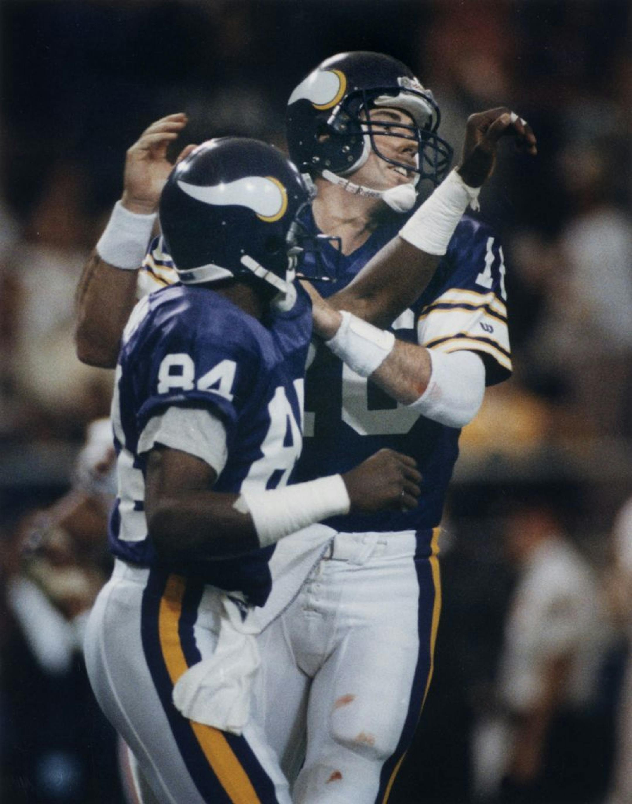 Minnesota Vikings pro football -- quarterback Rich Gannon (16) congratulates Hassan Jones (84) after Jones's five-yard touchdown reception in the second quarter of a 41-13 victory by the Vikings against Chicago at the Humphrey Metrodome (Minneapolis), Sunday November 25, 1990. Photo by Brian Peterson.