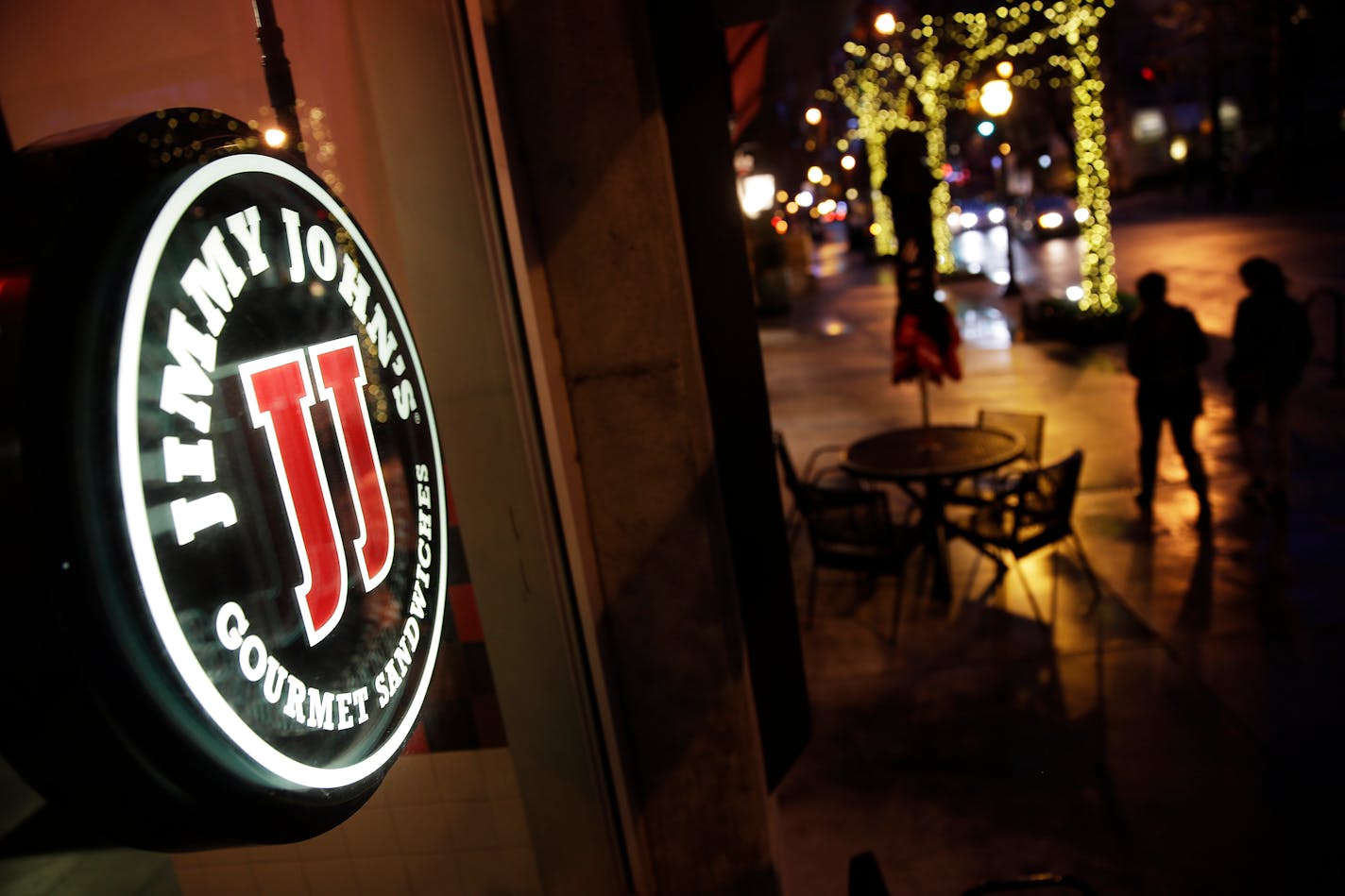 Pedestrians pass by a Jimmy John's sandwich shop, Friday, Jan. 2, 2015, in Atlanta.