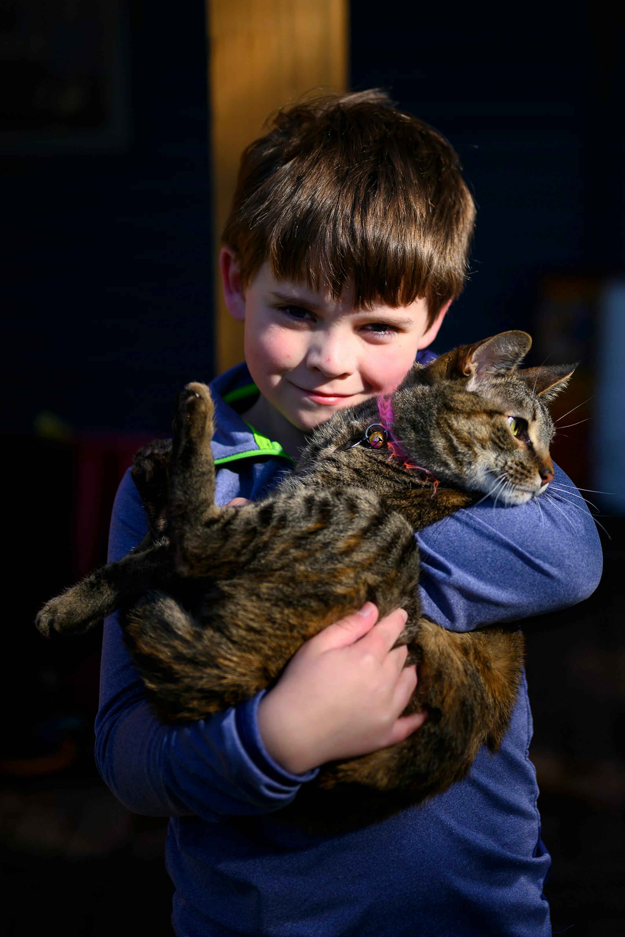 Link Gehring, 8, held his cat, Rocky, in the backyard of his family's Woodbury home Wednesday afternoon. "We have to stay at home which is very fun for me," said Link, whose mother says he's a bit of an introvert. "I miss my friends but I have less schoolwork now."