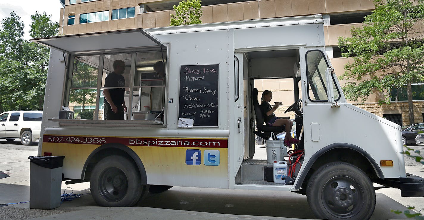 Olivia Boxrud, 9, the cashier ate her slice of pizza during break in the action during lunch time. ] (KYNDELL HARKNESS/STAR TRIBUNE) kyndell.harkness@startribune.com BB's Pizzeria food truck at Calvary Episcopal Church in Rochester, Min., Thursday, June 25, 2015. ORG XMIT: MIN1506251606441479