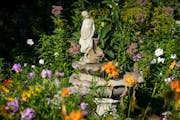 Daylilies, phlox and Joe Pye surround a statuary in Diana Weissenfluh's Zimmerman, Minn garden.