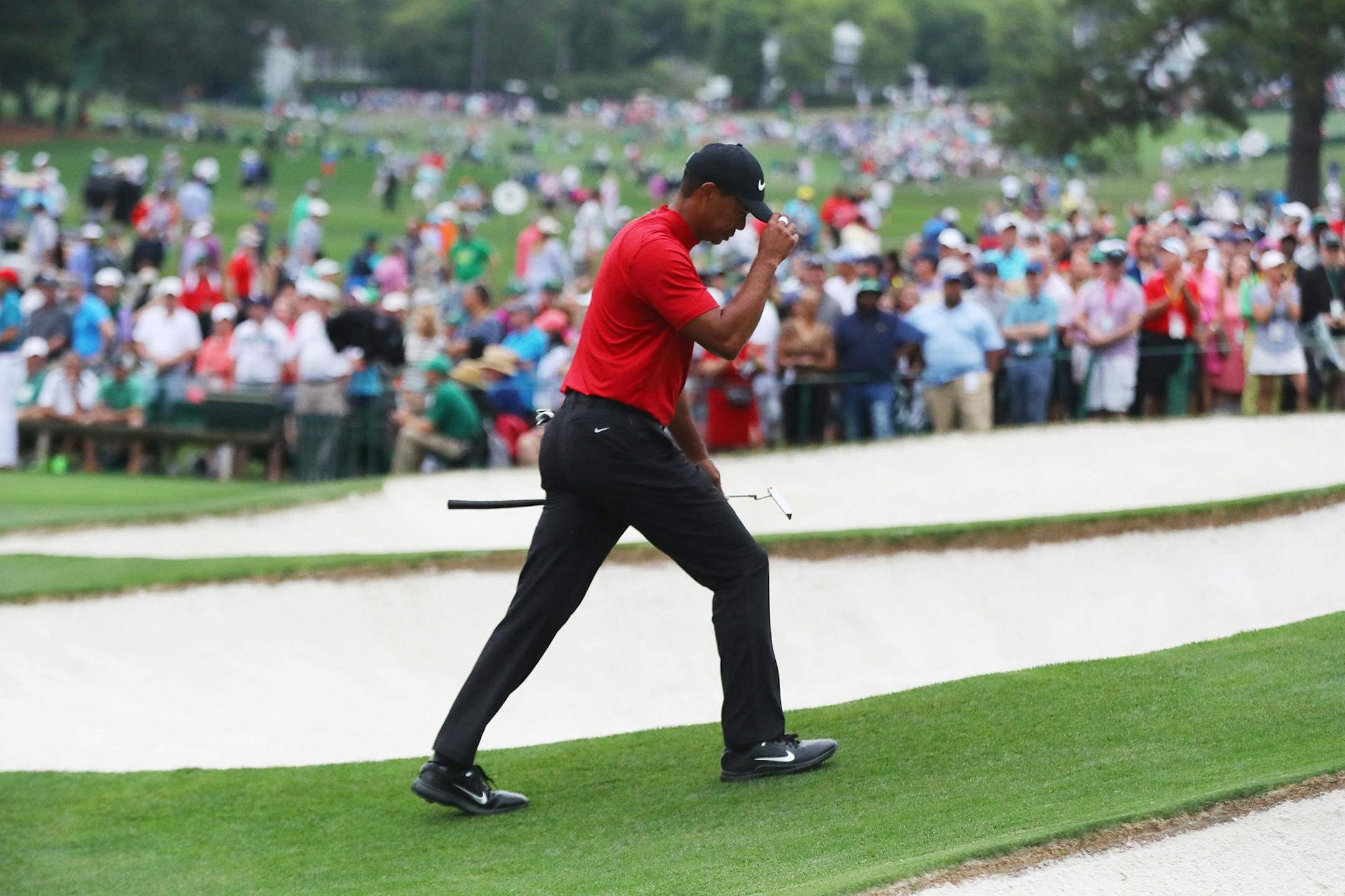 Tiger Woods tipped his cap as he walked to the green at No. 7 during the final round of the Masters on Sunday. At age 43, he slipped on his first green jacket since 2005.