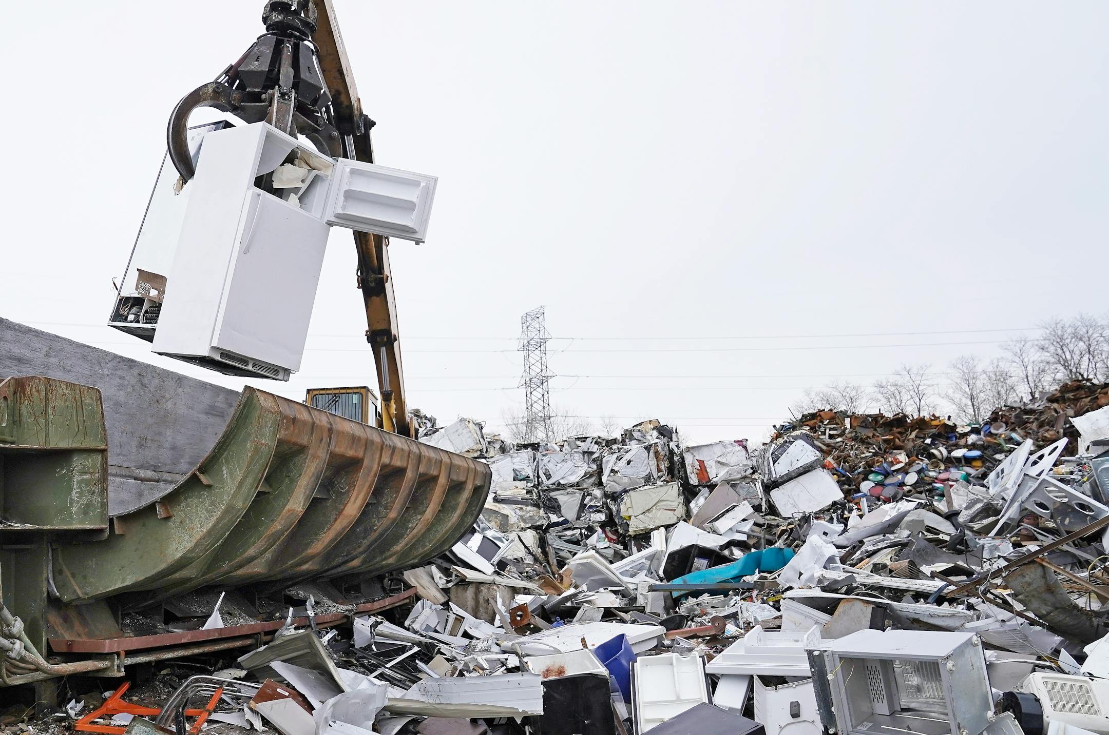 A claw from a logger/baler moves an old refrigerator into a hopper for recycling at J.R.'s Advanced Recyclers.