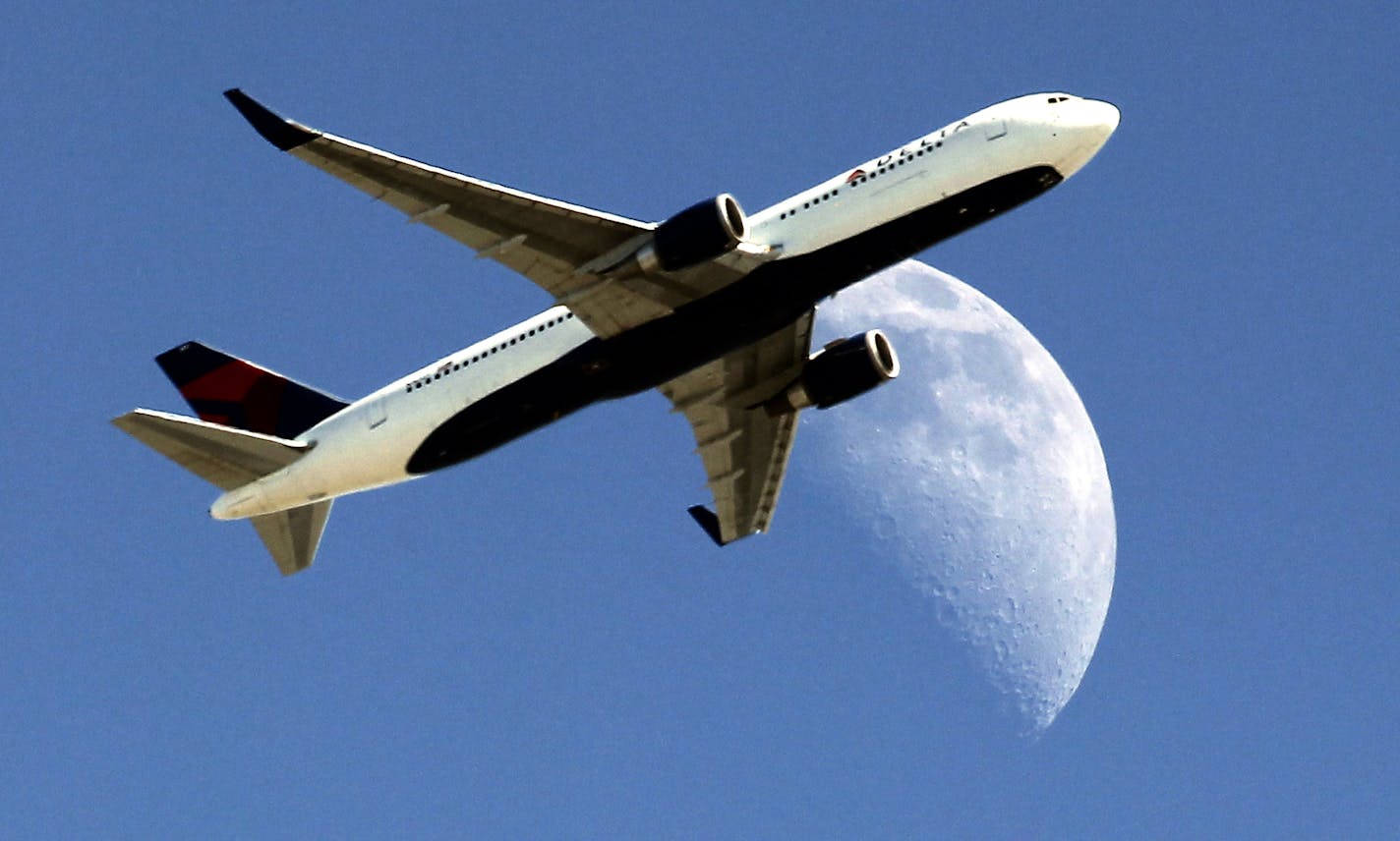 Delta Airlines flight DL370 from Managua Nicaragua crosses over a waxing crescent moon as it passes over Whittier, Calif. on approach to the Los Angeles Airport (LAX) on Labor Day, Monday, Sept. 1, 2014. (AP Photo/ Nick Ut )