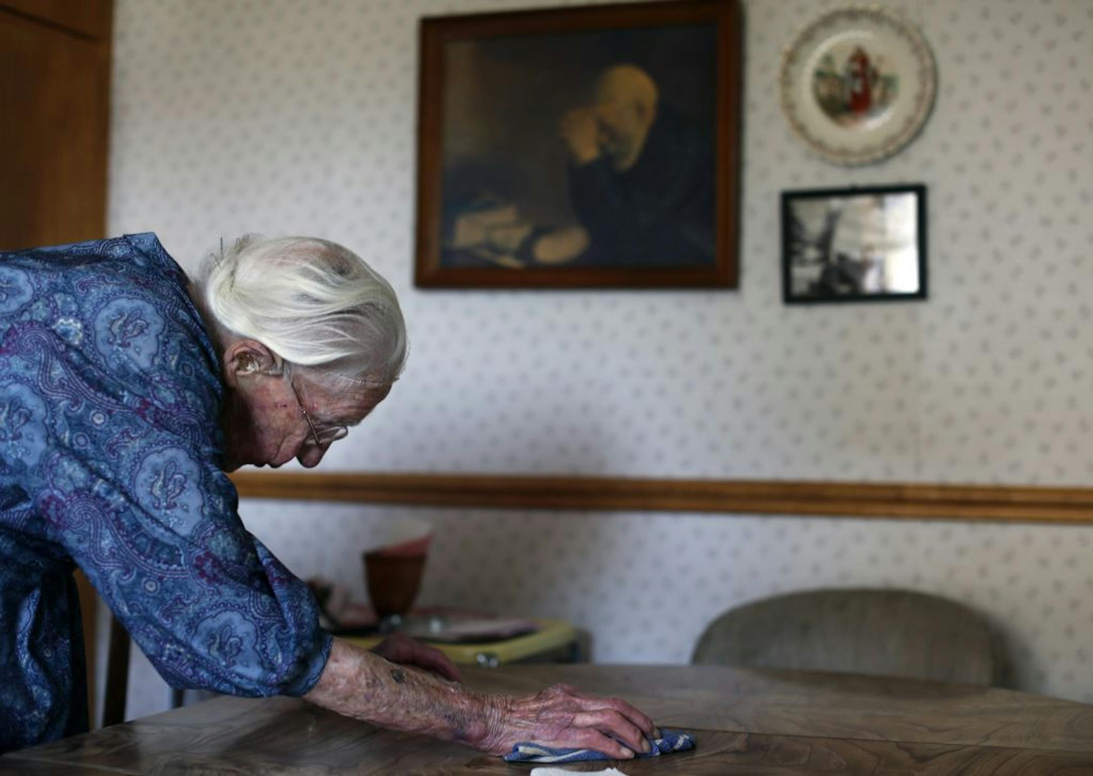 At her home in Pottsdam, Anna Stoehr cleans the table for lunch. She is perhaps the oldest person who lives alone. She does not have a special diet but likes to bakes her own bread. She also likes to eat liverwurst, butter, and bacon.