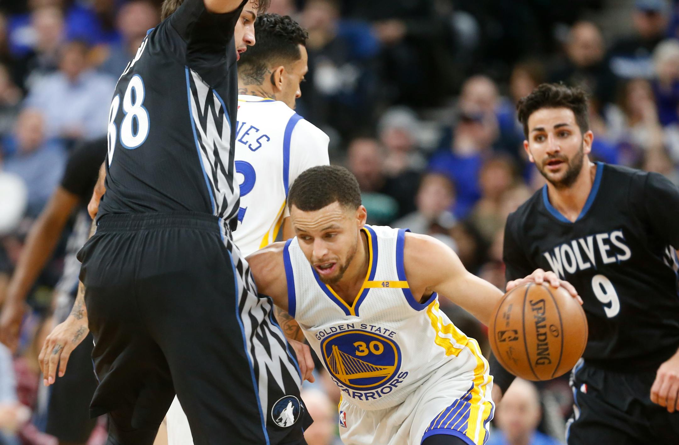Golden State's Stephen Curry, center, works around the Timberwolves' Nemanja Bjelica, left, during the first half Friday night.