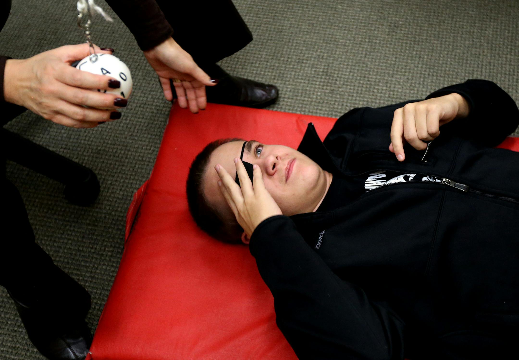 Luke Nelson followed a ball with his eyes as it swung past his face during a occupational therapy session with April J. Doten at CentraCare Health System rehabilitation center November 6, 2013 in St. Cloud , MN. One eye is covered with a patch, and the ball is swung in all directions, this exercise will strengthen the muscles around his eyes. ] JERRY HOLT ‚Ä¢ jerry.holt@startribune.com