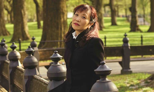 photo, in a park, of seated author Michiko Kakutani