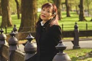 photo, in a park, of seated author Michiko Kakutani