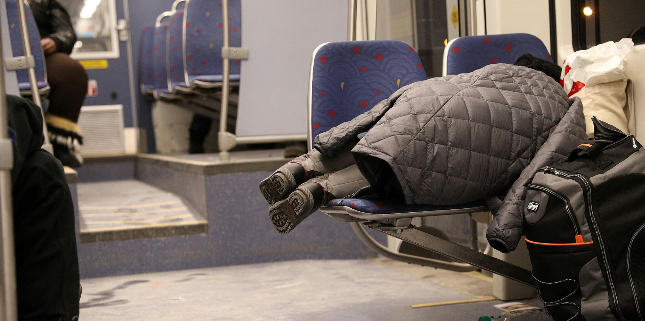 A woman slept across two seats on a Metro Transit light-rail train. ] ANTHONY SOUFFLE ¥ anthony.souffle@startribune.com Overnight riders sleep on the Metro Transit light-rail trains Thursday, Dec. 22, 2016 in Minneapolis. Each day, dozens of these sleeping passengers are roused by police, and told to move along. As cold weather finally descends on the Twin Cities, those lacking shelter seek it out in the warm, moving train cars that traverse the downtowns of Minneapolis and St. Paul, and se