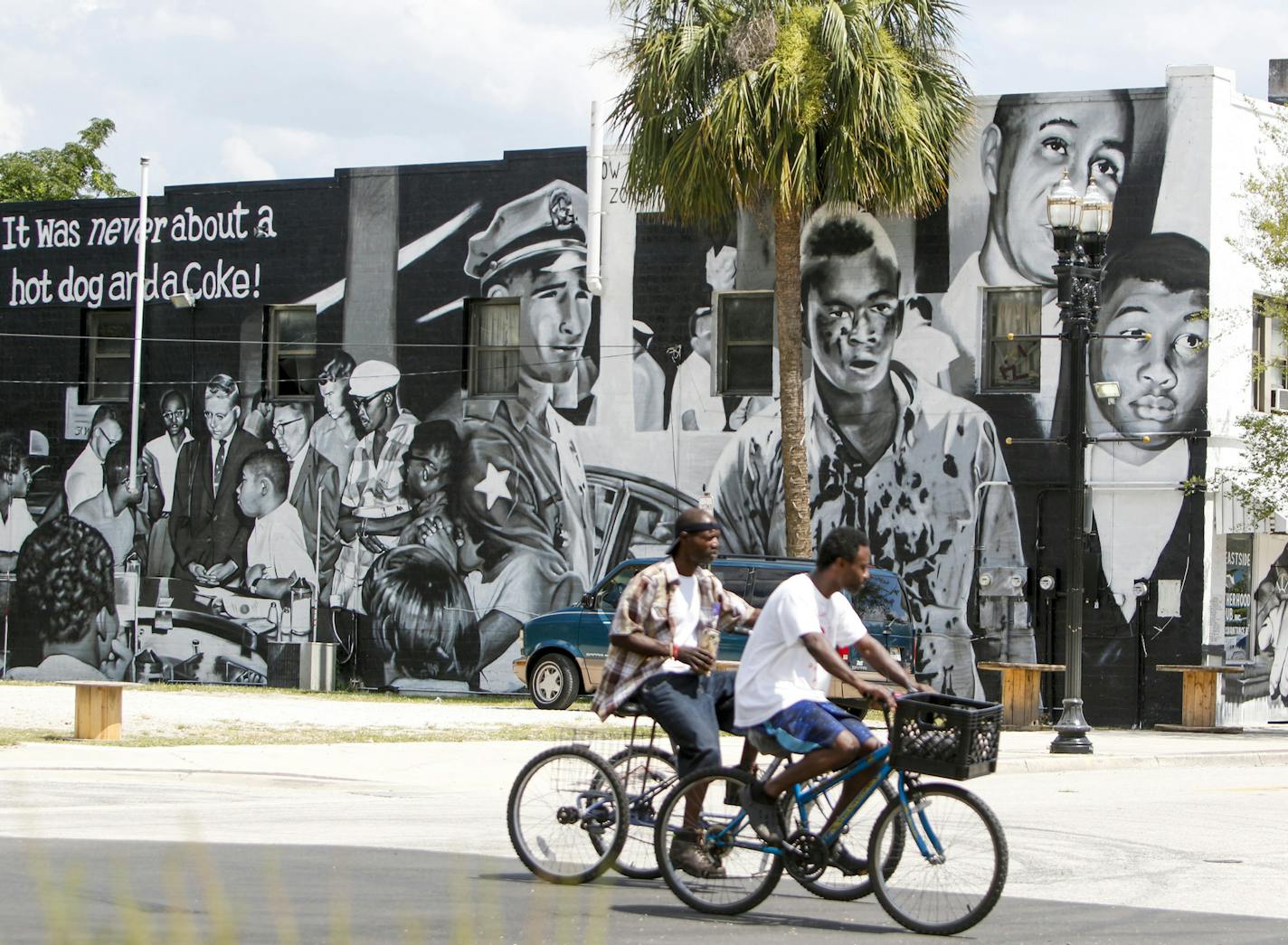 People bike past a mural on the Eastside Brotherhood Club building that depicts "Ax Handle Saturday" on Thursday, June 18, 2020 in Jacksonville. The Republican National Convention is scheduled to happen on the 60th anniversary of the day that the painting refers to, when African American teenagers were met with violence for sitting at a then segregated diner. (Ivy Ceballo/Tampa Bay Times/TNS)