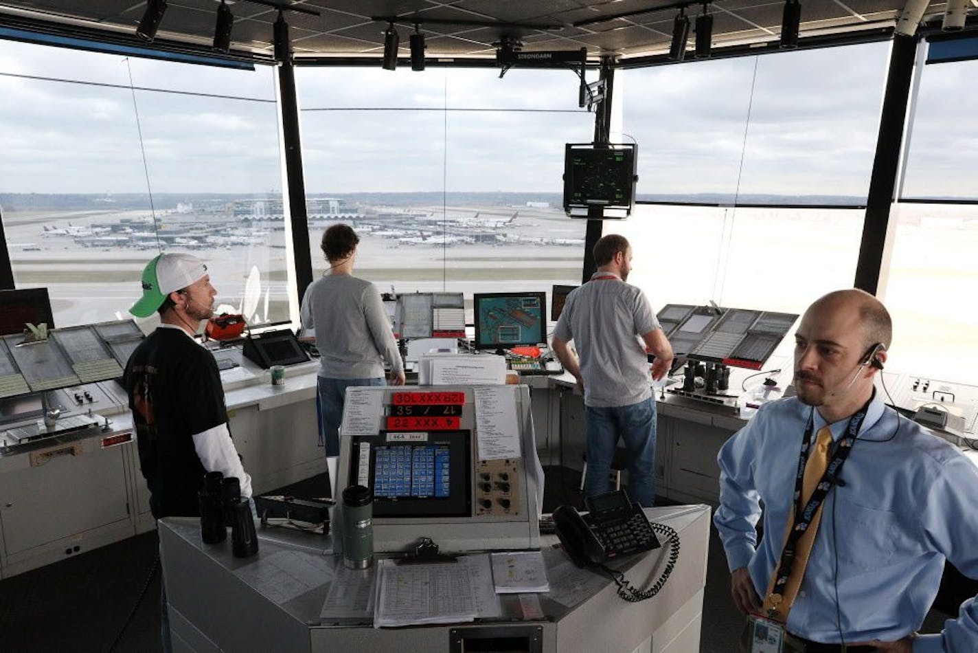 Air traffic controllers, including Justin Langerud, right, worked from the control tower at Minneapolis-St. Paul International Airport in April.