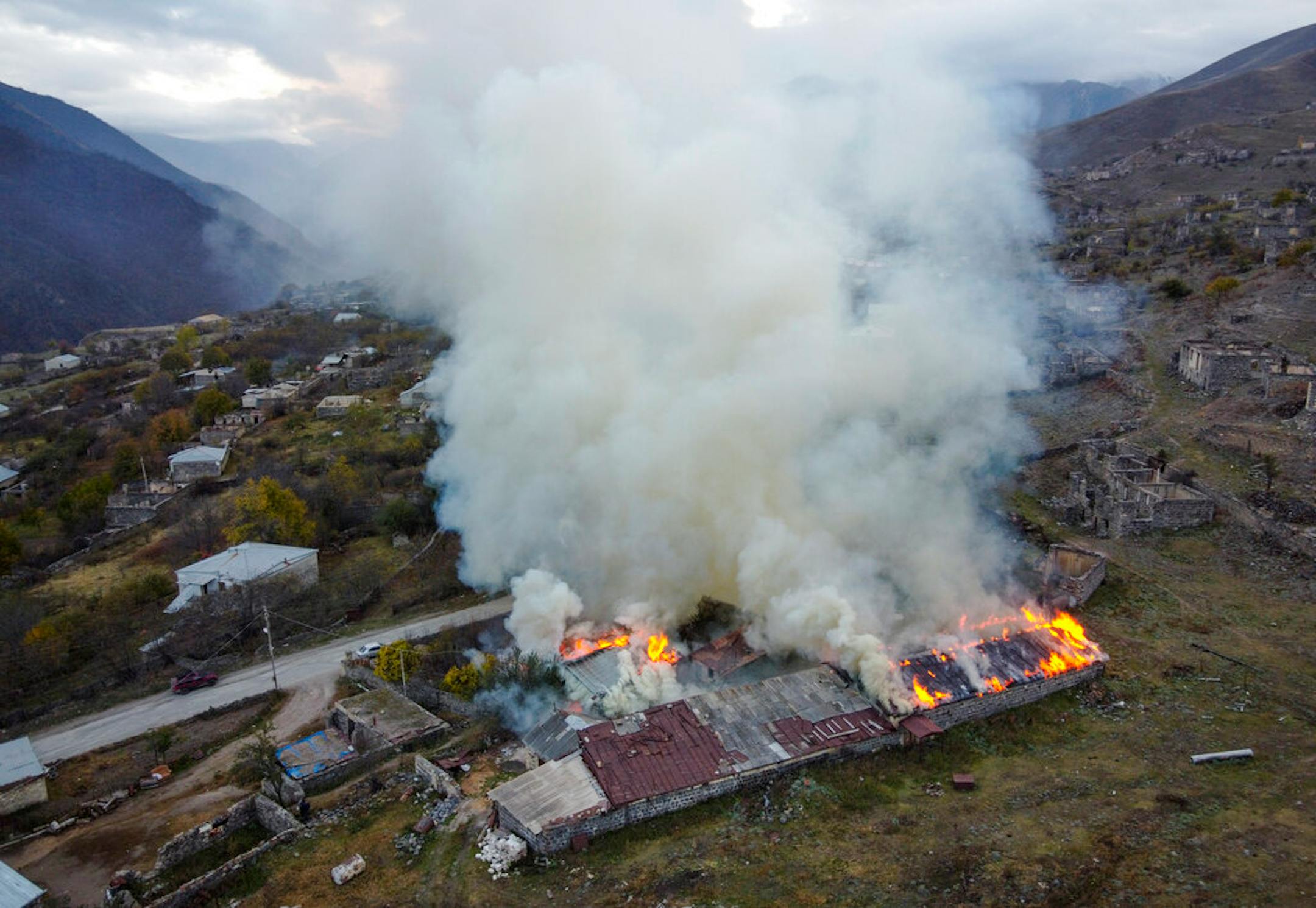 Smoke rises from a burning house in an area once occupied by Armenian forces but soon to be turned over to Azerbaijan, in Karvachar, the separatist region of Nagorno-Karabakh, on Friday, Nov. 13, 2020.