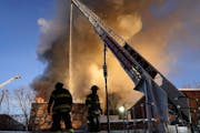 Minneapolis firefighters work a fire from an aerial ladder truck as a fire destroyed an empty apartment complex in the 2300 block of Lyndale Ave. S. I